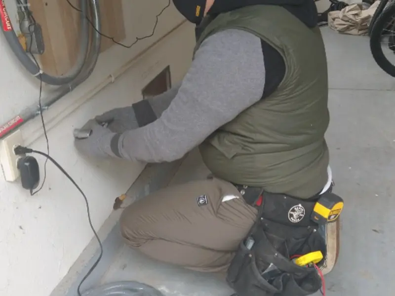 Electrician performing outlet wiring in a Madisonville garage